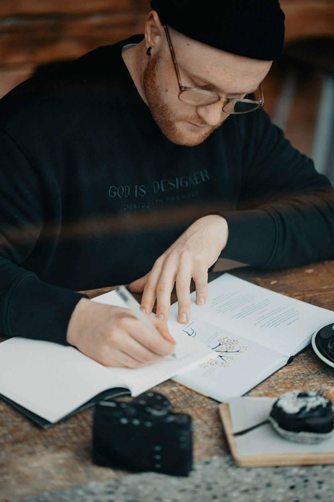 unsplash person sitting in a coffee shop writing in a journal with a smile 4v5l5mm tkc